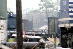 Extreme crop of some Apalachicola Northern pulpwood cars in background of loco photo.